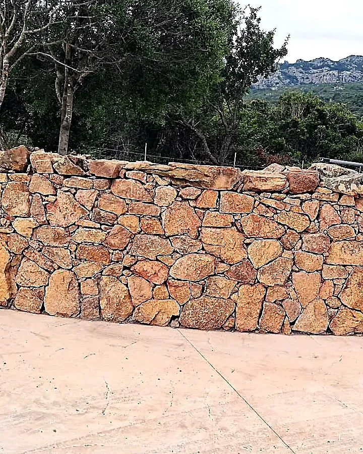 Muro a secco in granito della Gallura con vista sui monti, Aglientu